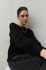 Sweater negro tramado de silueta relajada, con combinación de texturas en el tejido y mangas abullonadas con puños elastizados.