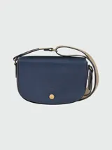 Bandolera Longchamp modelo Épure, color azul con correa ancha de tela color beige y cierre con botón a presión dorado.