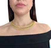 Gargantilla dorada con trama delicada que queda a la base del cuello.
