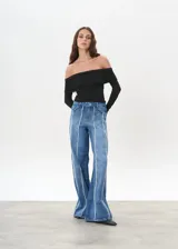 Pantalón de jean de tiro medio, corte wide leg, color azul con costuras verticales blancas en el frente.