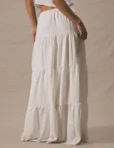 Pollera larga blanca de tiro alto, con volados en capas y abertura lateral ajustable con cordones.