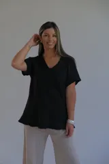 Remera negra de corte holgado con cuello en V y mangas cortas.