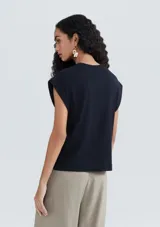 Musculosa azul marino de tejido de punto con cuello redondo y sisas amplias. Diseño minimalista y corte recto.