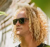 Lentes de sol con montura cuadrada de madera color marrón y lentes verdes.