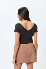 Top blanco de algodón con mezcla de poliéster y elastano, con escote en V delantero y trasero.