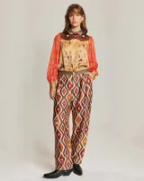 Pantalón recto con estampado geométrico en tonos marrón, naranja y blanco.