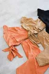 Chaqueta corta color camel con cuello solapa, corte cruzado y cierre con botón.
