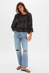 Blusa negra de encaje con cuello alto y mangas anchas con volados.