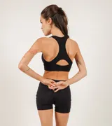 Top deportivo negro de microfibra sin costuras, con copas removibles y gran sujeción.