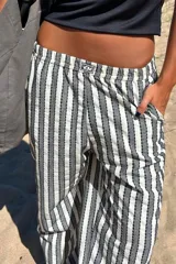 Pantalón de lino tusor con cintura elástica y bolsillos, diseño de rayas en tonos neutros.