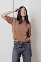 Sweater color dorado de tejido de punto suave con hilos metalizados, corte recto y mangas cortas con puño ajustado.