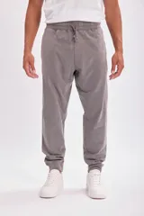 Pantalón deportivo tipo jogger color gris con cintura elástica y cordón ajustable.