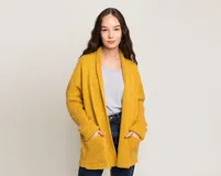 Cárdigan mostaza de lana merino con mangas largas y bolsillos delanteros.