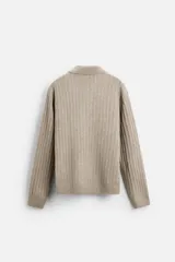 Sweater color beige de punto canalé con cuello polo, solapas amplias y cierre frontal con dos botones.