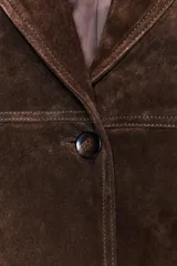 Abrigo largo marrón de ante, con cuello solapa, manga larga, bolsillos delanteros y cierre frontal con botones.