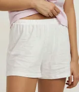 Conjunto de pijama de dos piezas en algodón estampado. Incluye una remera de manga corta con cuello redondo y un short con cintura elástica. La remera es de color lila con estampado de la palabra 'Lovely' y el short es blanco con estampado de gatitos.