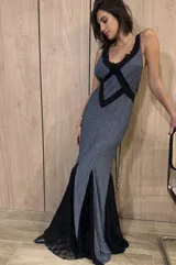 Vestido largo de silueta fluida, entallado en el torso, con escote profundo y espalda descubierta con tiras cruzadas. Confeccionado en jersey con lurex y terminaciones en encaje negro.