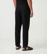 Pantalón de vestir negro, de corte slim cropped, con cintura elástica, cierre con cremallera y bolsillos laterales.