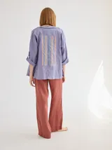 Camisa color coral de lino, corte holgado, escote redondo y mangas 3/4 ajustables con botón.