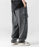 Pantalón de jean negro con efecto lavado, estilo cargo y corte muy holgado (baggy). Posee cintura elástica ajustable y bolsillos cargo laterales.
