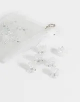Set de 20 minibroches negros para el cabello, presentados en una bolsita plástica transparente con cierre y cadena metálica.