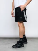Short deportivo negro de poliéster y elastano, con laterales en contraste color gris y logo de la marca Umbro en la pierna izquierda.
