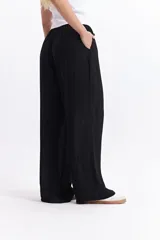 Pantalón negro de tiro alto con elástico y cordón regulable.