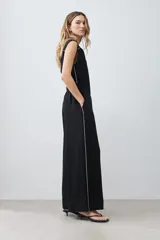 Mono negro de lino con corte recto, cuello camisero, sin mangas y vivo blanco en contraste en cuello, sisas y laterales.