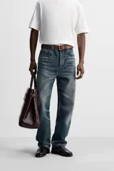 Pantalón de jean azul con efecto lavado, corte recto y largo al tobillo.