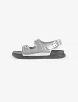 Sandalias plateadas con tiras anchas y plantilla cómoda, con tira ajustable en el talón. Fabricadas en cuero vegano.