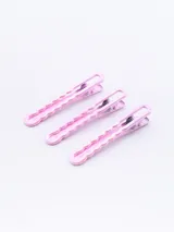 Pack de tres pinzas para el pelo color rosa con diseño ondulado.