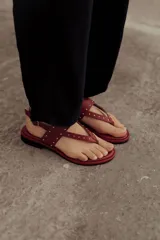 Sandalias marrones de cuero con tiras, microtachas doradas y hebilla lateral.