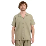 Camisa manga corta color verde con textura arrugada, cuello solapa, cierre con botones y bolsillo de parche en el pecho.