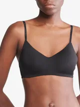 Corpiño negro Calvin Klein con escote en V, tirantes finos ajustables con logo de la marca, copas con relleno ligero sin aros y cierre trasero con broche.