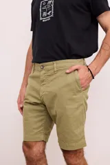 Bermuda de gabardina color verde oliva, con bolsillos laterales y traseros. Cierre frontal con botón y cremallera.