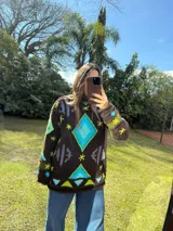 Sweater tejido de lana color azul marino con diseño geométrico en blanco.