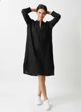 Vestido negro a la rodilla de algodón, manga larga con cuello mao y corte recto.