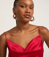 Blusa de tirantes finos color vino tinto, con escote drapeado (degagê) y acabado satinado. El bajo es asimétrico.