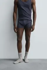 Conjunto de pijama color gris compuesto por una camiseta sin mangas de corte ajustado y un bóxer corto con cintura elástica y botones.