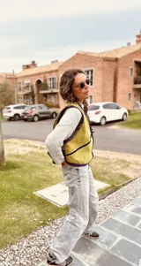 Chaleco amarillo con ribete azul marino, sin mangas y con cierre frontal con cordones.