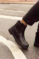 Bota corta de cuero color marrón, con suela de goma negra y cierre lateral con cremallera.