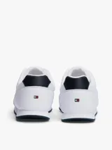 Zapatillas Tommy Hilfiger blancas de estilo running, con suela dentada fina y logo de la marca en el lateral.