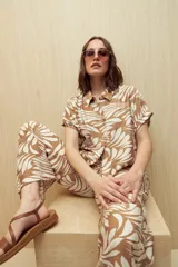 Camisa de manga corta con estampado de hojas en tonos azul y blanco, con botones frontales y puños con vuelta.