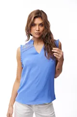 Blusa color crema con escote en V, sin mangas y detalle de encaje en hombros y cuello.