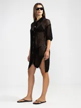 Camisa larga negra de punto calado con cuello camisero, manga tres cuartos y cierre frontal con botones.