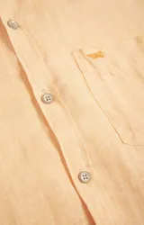 Camisa de manga larga color durazno, confeccionada en lino orgánico, con cuello italiano, cierre con botones y bolsillo en el pecho con logo bordado al tono.