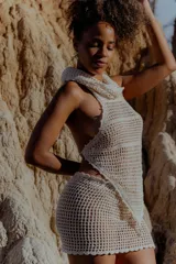 Top tejido al crochet color crudo, con capucha integrada y espalda descubierta.