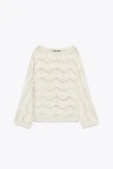Sweater color crudo de punto calado con cuello barco y manga larga acampanada.