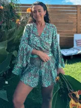 Conjunto de dos piezas estampado, compuesto por un top cruzado de manga larga acampanada y un short a juego. El estampado es de estilo paisley en tonos turquesa y marrón.