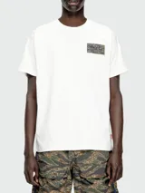 Remera blanca de algodón con parche rectangular estampado en el pecho. Corte clásico y cuello redondo.